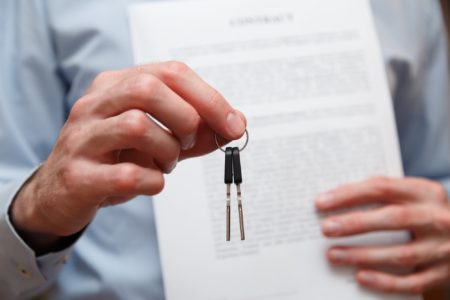 Businessman offering a key with contract. Rental agreement with contract