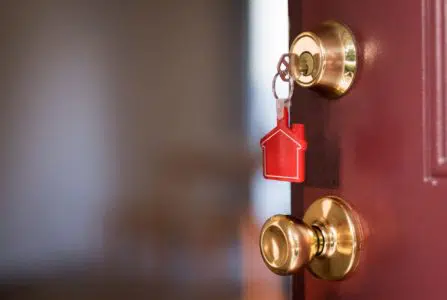 House key in the door opening into apartment